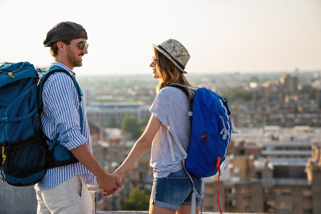 Happy tourists couple, friends sightseeing city with map together. Travel people concept.